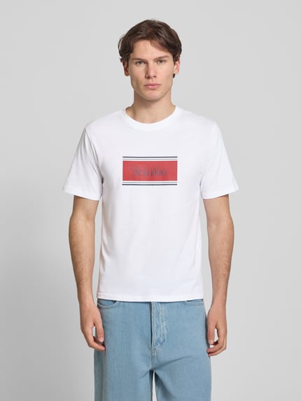 Männermodel trägt Regular Fit T-Shirt mit Logo-Print Modell 'Buster' von JACK & JONES aus Reine Baumwolle, Herren T-Shirt, Ganzkörperansicht von vorne. Rückenlänge bei Größe M: 71 cm.