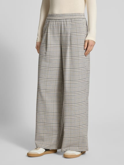 Vrouwenmodel draagt Weite Hose met Viskose-Anteil van Marc O'Polo Denim, look: effen, wide leg pasvorm, geruit patroon, applicatie met labelstitching, bandplooi, elastische boord, zij-steekzakken, webware materiaalverwerking. Ganzkörperaanzicht van voren.