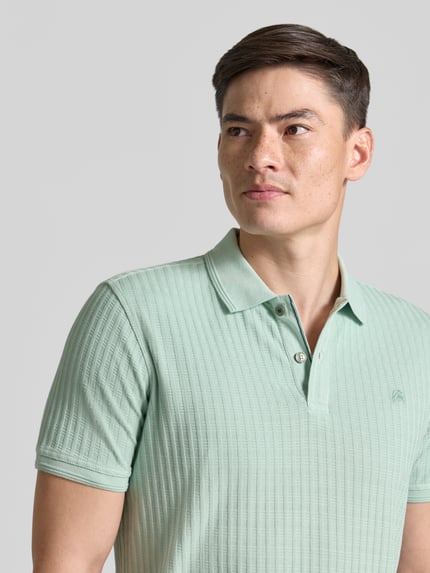 Männermodel trägt Slim Fit Poloshirt mit Logo-Stitching von Lerros in Mintgrün, Baumwoll-Mix, Polokragen, Knopfleiste, Nahaufnahme Oberkörper.
