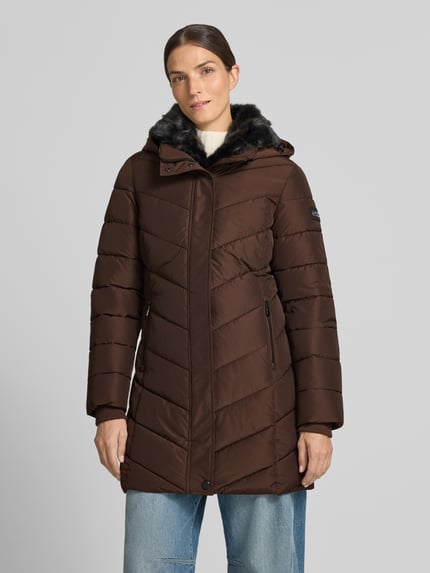 Frauenmodel trägt Jacke mit abnehmbarer Kapuze von NAUTGÅRD in Braun mit schwarzem Kunstfell, seitlichen Reißverschlusstaschen, Ganzkörperansicht von vorne. Rückenlänge, Schulterbreite, Brustweite und Ärmellänge in Größe S laut Produktangabe.