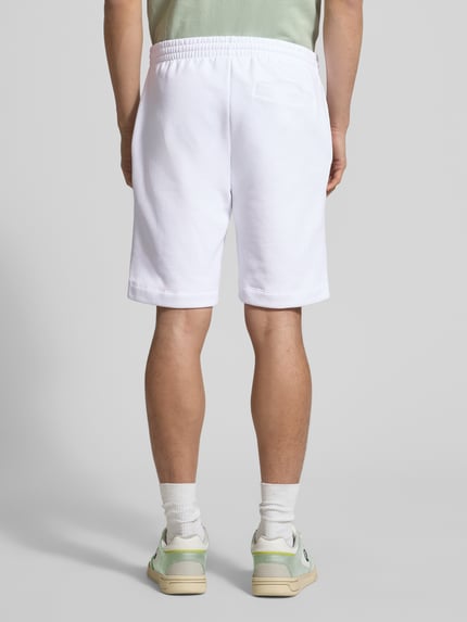 Männermodel trägt Regular Fit Sweatshorts aus Baumwoll-Mix von Lacoste, Optik: Unifarben, Materialverarbeitung: Sweat, Ganzkörperansicht Rückansicht.