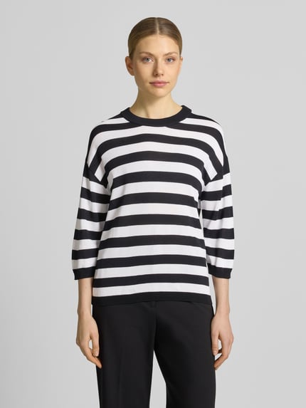 Modelka nosi Regular Fit Oberteil aus Viskose-Mix Modell 'Lani' od GUIDO MARIA KRETSCHMER WOMAN, czarno-białe paski, imitacja dzianiny, rękaw o dł. 3/4, okrągły dekolt, elastyczne zakończenia rękawów, tył 58 cm, rękaw 34 cm, mieszanka wiskozy, efekt (góra): imitacja dzianiny, góra, całkowity widok z przodu.