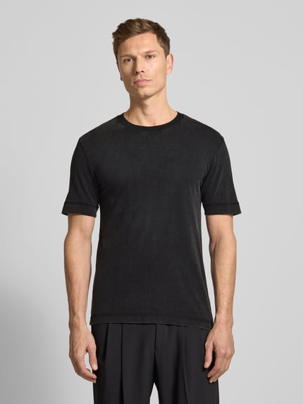 Männermodel trägt T-Shirt mit geripptem Rundhalsausschnitt von Drykorn in Schwarz, reine Baumwolle, Regular Fit, Ganzkörperansicht von vorne.