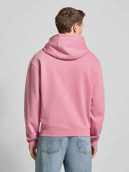 Männermodel trägt Hoodie mit Kapuze Modell 'KAMILIO' von Drykorn in Rosa, lockerer Schnitt, Baumwoll-Mix, Ganzkörperansicht Rückansicht