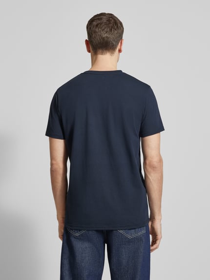 Männermodel trägt T-Shirt mit Label-Print Modell 'Jeramy' von Matinique aus Baumwoll-Elasthan-Mix in Dunkelblau, Ganzkörperansicht Rückansicht.