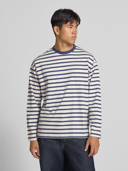 Männermodel trägt Regular Fit Longsleeve aus reiner Baumwolle mit Streifenmuster von JACK & JONES, Rundhalsausschnitt, Ganzkörperansicht von vorne.