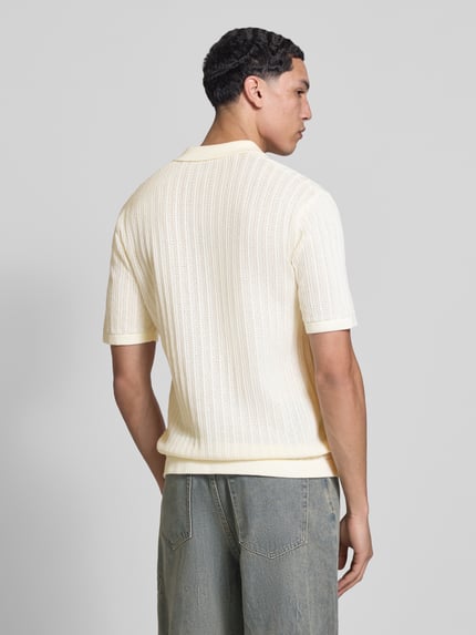 Männermodel trägt Regular Fit Poloshirt aus Baumwoll-Mix Modell 'MOON' von Only & Sons in Strickoptik, hell, Strukturmuster, Ganzkörperansicht Rückansicht.