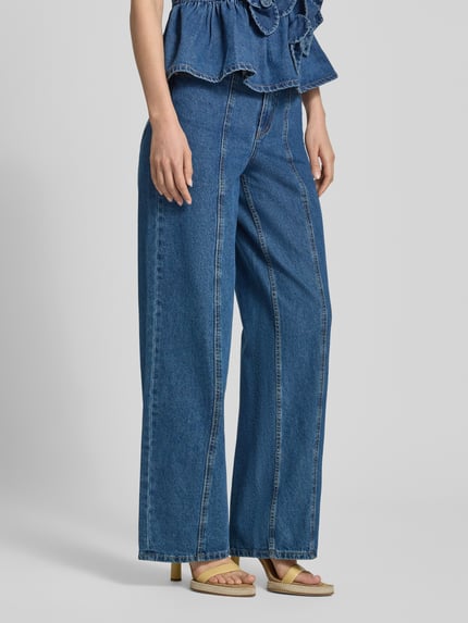 Kobiece modelka nosi Wide Fit Jeans mit Ziernähten Modell 'Elsie' od YAS, 5-kieszeniowy design, niebieski denim, szerokość w rozmiarze 27/32: 37 cm, długość nogawki wewnętrznej 83 cm, widok całej sylwetki z przodu.