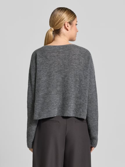 Vrouwenmodel draagt gebreide pullover uit alpacamix met wol, model 'MENY' van DRYKORN, los model, grijs, ruglengte maat S 50 cm, mouwlengte 70 cm, geribde ronde hals, Ganzkörperansicht Rückansicht