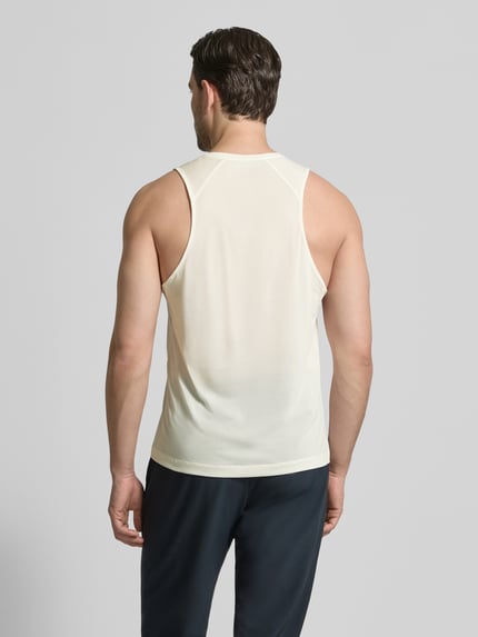 Männermodel trägt Tanktop mit Rundhalsausschnitt und Logo von Salomon in Offwhite, glatte Textur, Rückenlänge 69 cm, Ganzkörperansicht Rückansicht.