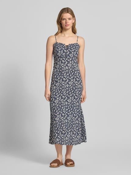 Modelka kobieca ma na sobie Schmales Freizeitkleid aus reiner Viskose Modell 'NELLY' od Only, wzór animal print, długość midi, Henley, cienkie ramiączka, popelina, kolor granatowy z białym nadrukiem, krój slim fit, widok całej sylwetki z przodu.