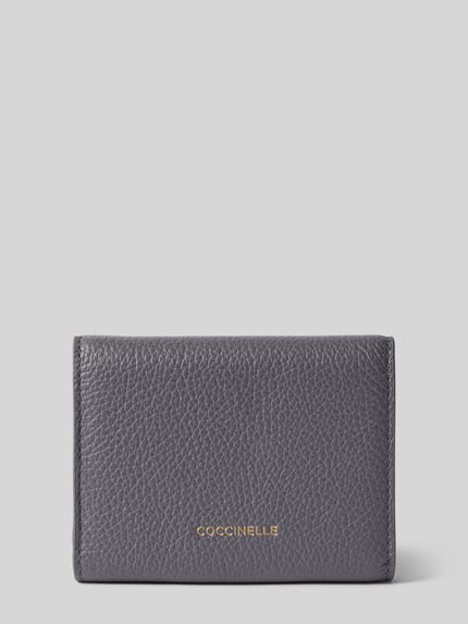 Produktfoto, Portemonnaie mit Label-Detail von Coccinelle in Dunkelgrau mit Strukturmuster, metallic Label, Verschluss mit Druckknopf, Münzfach und mehreren Fächern