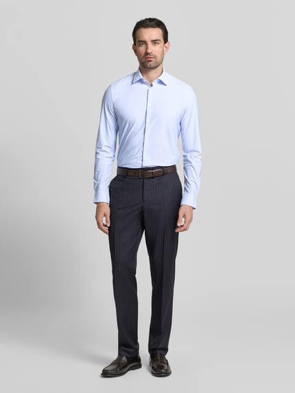 Männermodel trägt lichtblauw Slim Fit Business-Hemd mit Kentkraag van Jake*s, elastische materiaalmix, gladde structuur, langärmelig, knoopsluiting, sportmanchet; geheel vooraanzicht, geheel zichtbaar.