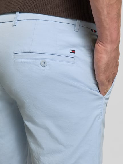 Männermodel trägt Regular Fit Bermudas aus Baumwoll-Mix von Tommy Hilfiger, Optik: Unifarben, Logo-Stitching, Detailaufnahme Rückansicht.