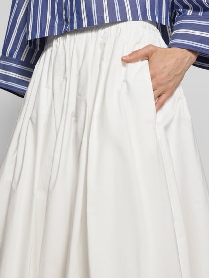 Männermodel trägt Ausgestellter Maxi-Rock aus reiner Baumwolle Modell 'NUVOLE' von Weekend Max Mara, unifarben, krój regular fit, długość maxi, prosta linia dołu, balon, boczne kieszenie, gładka tekstura, biała tkanina, widoczna struktura materiału, detalowana faktura, zdjęcie: nahaufnahme okolic pasa.