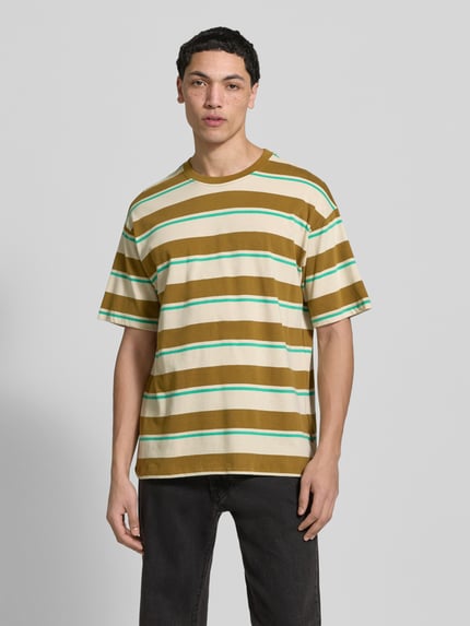 Männermodel trägt T-Shirt mit Streifenmuster Modell 'KYRAN' von Blend aus reiner Baumwolle, Regular Fit, braun-weiß-grün, Ganzkörperansicht von vorne.
