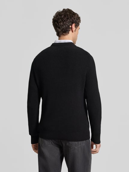 Männermodel trägt Regular Fit Strickpullover aus reiner Baumwolle von MCNEAL in Schwarz, elastische Abschlüsse, Ganzkörperansicht Rückansicht.