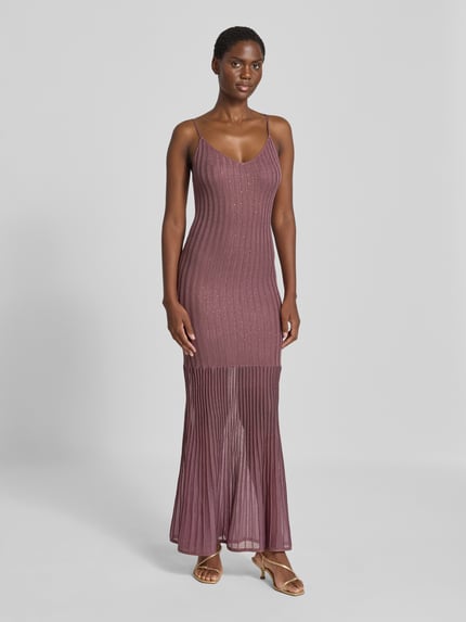 Frauenmodel trägt Strickkleid in Ripp-Optik Modell 'MEENA' von GUESS in Rosa mit Ziersteinbesatz, figurbetont, Maxilänge, Ganzkörperansicht von vorne.