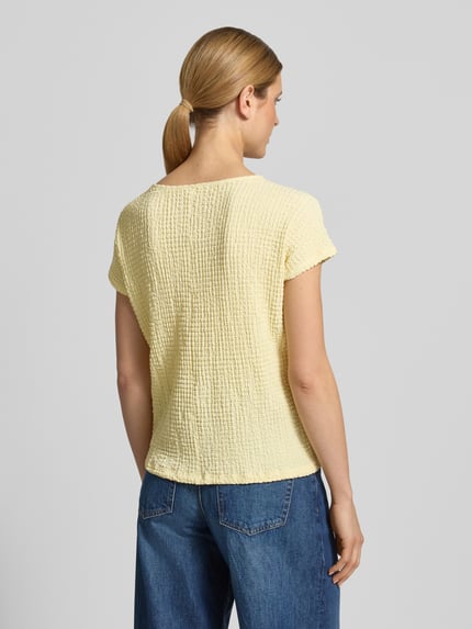 Modelka nosi Relaxed Fit T-Shirt mit Strukturmuster von s.Oliver RED LABEL, efekt: jednolity kolor, z fakturą, krój relaxed fit, okrągły dekolt, rękaw: krótki rękaw, wykończenie materiału: marszczenie, damski t-shirt, widok całej sylwetki z tyłu