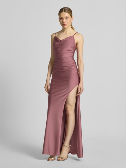 Frauenmodel trägt Abendkleid mit seitlichem Gehschlitz und Wasserfall-Ausschnitt von Mascara aus Satin im Körpernaher-Schnitt als Maxikleid, mit Spaghettiträger und Haken-Reißverschluss, warme mauve Farbe, glatte Oberfläche, Ganzkörperansicht von vorne. Rückenlänge bei Größe 36: 125 cm, Brustweite bei Größe 36: 40 cm.