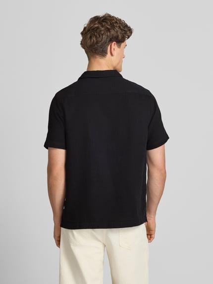 Männermodel trägt Regular Fit Freizeithemd mit Kentkragen und Brusttaschen von Superdry in Schwarz, Strukturmuster, Rückenansicht, Rückenlänge 70 cm, Schulterbreite 54 cm, Ärmellänge 30 cm, Reine Baumwolle. Ganzkörperansicht Rückansicht.