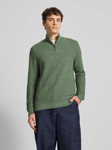 Männermodel trägt Troyer mit Stehkragen von Superdry in Grün, Reine Baumwolle, Regular-Fit, Gerippte Abschlüsse, Ganzkörperansicht von vorne.