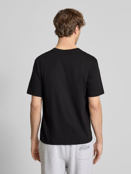 Männermodel trägt T-Shirt mit Label-Stitching Modell 'NORREBRO' von Jack & Jones, schwarz, reine Baumwolle, Ganzkörperansicht Rückansicht