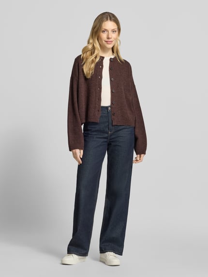 Frauenmodel trägt Cardigan aus Alpaka-Mix Modell 'MARWENI' von DRYKORN in Braun, locker geschnitten, strukturierte Oberfläche, Ganzkörperansicht von vorne.