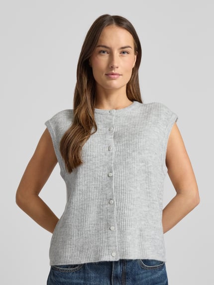 Frauenmodel trägt Loose Fit Strickweste mit Knopfleiste Modell 'Everest' von Neo Noir, grau, gerippte Textur, vorne, Nahaufnahme Oberkörper.
