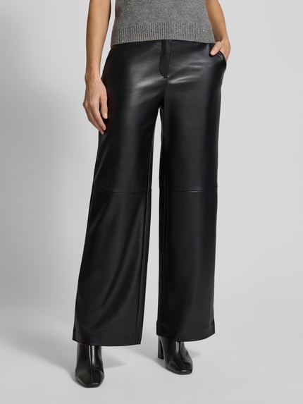 Vrouwenmodel draagt Stoffen broek in leerlook van Comma, los model, steekzakken, achterzakken, zwart, binnenbeenlengte 76 cm. Nahaufnahme onderlichaam.