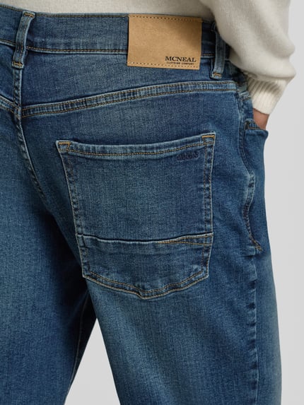 Männermodel trägt Regular Fit Jeans mit Eingrifftaschen von MCNEAL in Dunkelblau mit Gesäßtaschen, Detailaufnahme Rückansicht.