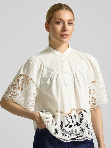 Frauenmodel trägt Regular Fit Bluse mit Spitze Modell 'LINDA' von SUNCOO PARIS, reine Baumwolle, weiß, Stehkragen, Nahaufnahme Oberkörper.