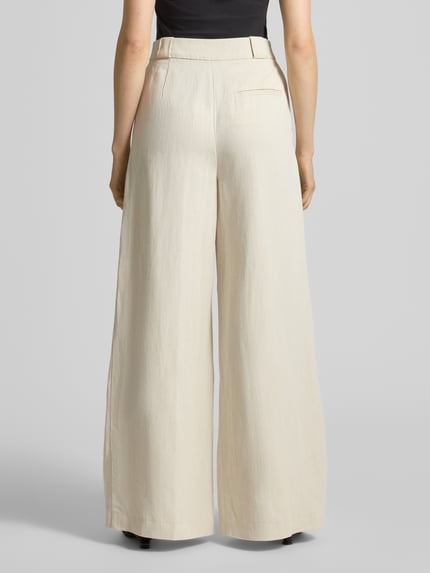 Kobiece modelka nosi Loose Fit Weite Hose aus Viskose-Leinen-Mix od Marc O'Polo, jasny beż, szerokie nogawki, tkanina o gładkiej fakturze, tył z wysokim stanem i kieszenią, widok całej sylwetki z tyłu.