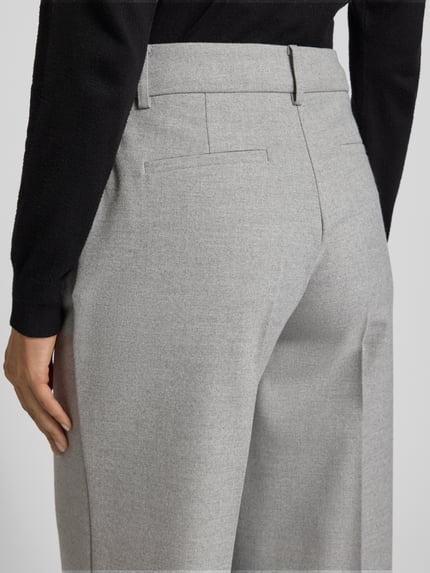 Frauenmodel trägt Stoffhose mit Bundfalten von More & More in Hellgrau, Material-Mix mit Viskose, Detailaufnahme Rückansicht.