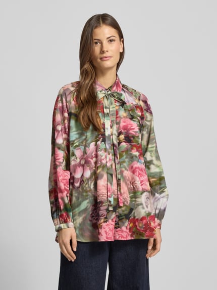 Frauenmodel trägt Hemdbluse mit Knopfleiste von More & More aus reiner Baumwolle, locker geschnitten, buntes florales Muster, Ganzkörperansicht von vorne.