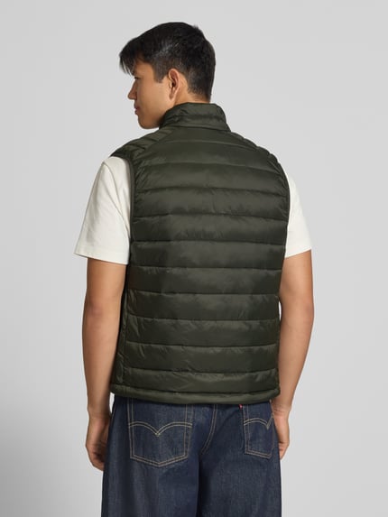 Männermodel trägt Steppweste mit Reißverschlusstaschen Modell 'KINGSLEY' von JACK & JONES in Dunkelgrün, Ganzkörperansicht Rückansicht.