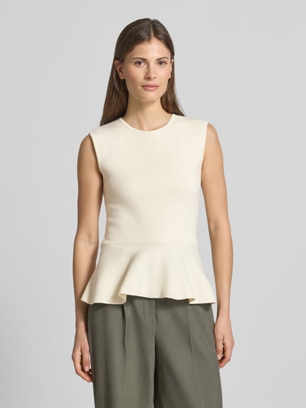 Frauenmodel trägt Regular Fit Top aus Viskose-Mix Modell 'FILLO' von BOSS, cremefarben, Schößchen-Saum, Feinstrick, Ganzkörperansicht von vorne.