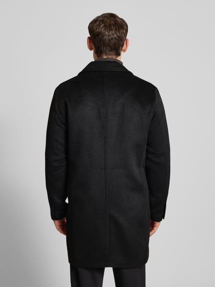 Männermodel trägt Mantel mit Stehkragen Modell 'BLASTANFORD' von Jack & Jones Premium in Schwarz, Material-Mix, Ganzkörperansicht Rückansicht.
