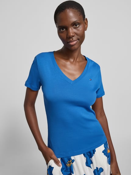 Vrouwenmodel draagt Slim Fit T-shirt uit puur katoen van Tommy Hilfiger, look: effen kleuren, V-hals, korte mouw, jersey, applicatie met gestikt logo, nahaufnahme bovenlichaam.