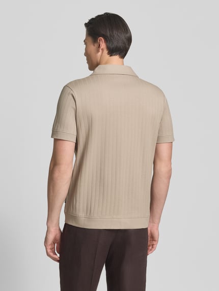 Männermodel trägt Regular Fit Poloshirt mit durchgehender Knopfleiste von JOOP! Collection in Beige, gerippte Struktur, Ganzkörperansicht Rückansicht. Modell 'Juanmanuel', reine Baumwolle, Rückenlänge 72 cm, Schulterbreite 46 cm, Ärmellänge 24 cm.