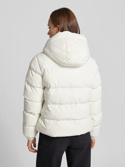 Frauenmodel trägt Regular Fit Jacke in Stepp-Optik von Superdry in Creme, Kapuze mit Tunnelzug, Ganzkörperansicht Rückansicht. Kontext: Damen Jacke von Superdry, Stepp-Optik, Regular Fit, Kapuze mit Tunnelzug, Reißverschluss, Rückenlänge bei Größe S: 58 cm, Schulterbreite bei Größe S: 46 cm, Brustweite bei Größe S: 52 cm, Ärmellänge bei Größe S: 64 cm.