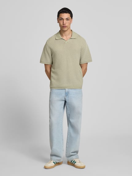 Męski model nosi Regular Fit Poloshirt mit V-Ausschnitt od Jack & Jones, bawełna, krój regular fit, kolor jasnobeżowy, przód, zdjęcie całopostaciowe.