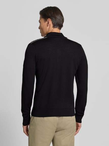 Männermodel trägt Wollpullover mit Label-Patch Modell 'Liaset' von Dale of Norway in Schwarz, gerade Form, Rückansicht, reine Wolle.