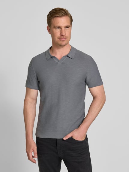 Männermodel trägt Regular Fit Poloshirt aus reiner Baumwolle von s.Oliver RED LABEL, Optik: Unifarben, Strick, Ganzkörperansicht von vorne.