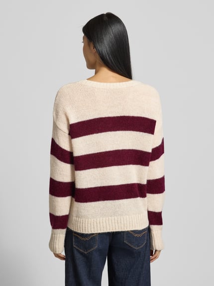 Frauenmodel trägt Strickpullover mit Rundhalsausschnitt von Milano Italy, Material-Mix mit Alpaka, cremefarben mit bordeauxroten Streifen, Rückenlänge 58 cm, Regular Fit, Ganzkörperansicht Rückansicht.