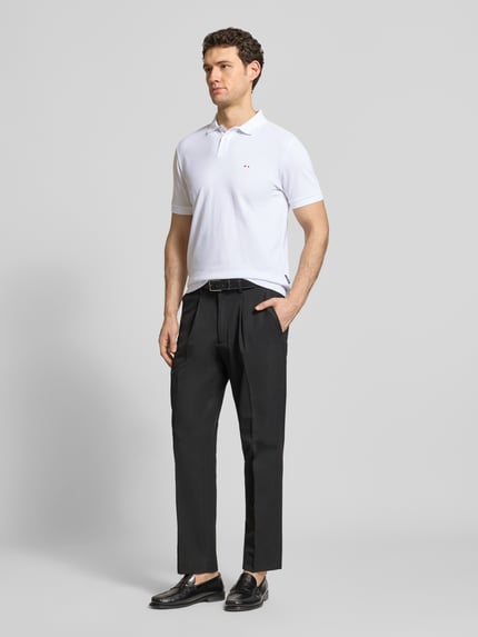 Männermodel trägt Regular Fit Poloshirt aus Baumwolle von HECHTER PARIS in Weiß mit Polokragen und Label-Detail, Ganzkörperansicht von vorne.