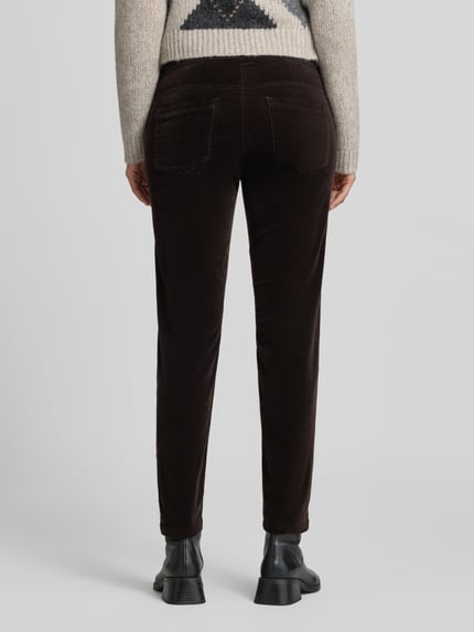Vrouwenmodel draagt Slim Fit broek met lyocell-aandeel in verkorte pasvorm van Luisa Cerano, donkerbruin, 5-pocketmodel, ganzkörperansicht achteraan, elastische mix van katoen en lyocell, bandwijdte maat 36: 35 cm, binnenbeenlengte maat 36: 70 cm.