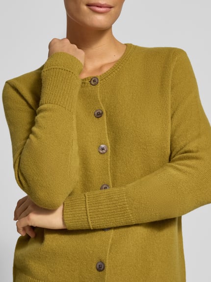 Frauenmodel trägt Cardigan aus Wolle mit Rundhalsausschnitt von Christian Berg Woman, Regular Fit, olivgrün, Nahaufnahme Oberkörper.
