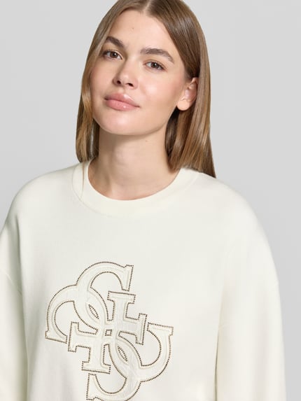 Vrouwenmodel draagt Longsleeve met Cut Out model 'EVELYN' van GUESS, slim fit, stretch-materiaalmix, label-applicatie, crèmekleurig, Nahaufnahme bovenlichaam.