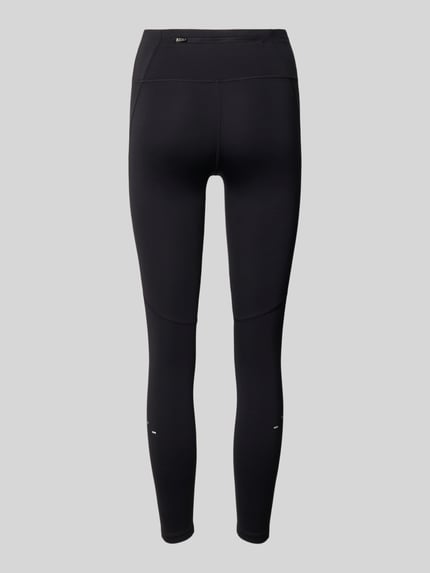 Frauenmodel trägt Leggings mit Logo von Nike, schwarze Farbe, Material-Mix mit Stretch-Anteil, Körpernahe Passform, Elastischer Bund, Ganzkörperansicht Rückansicht.